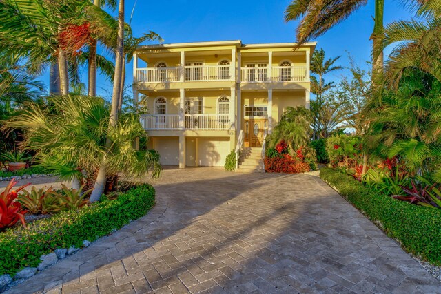 160 1st St, Key Colony, FL 33051 - view of front of house featuring a balcony, stairs, a garage, decorative driveway, and stucco siding