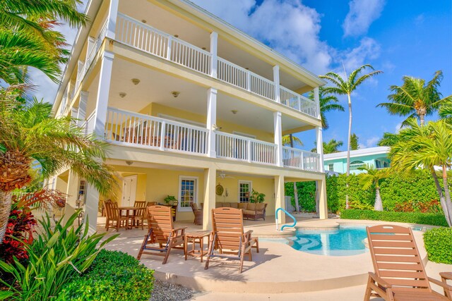 160 1st St, Key Colony, FL 33051 - rear view of house with a balcony, an outdoor hangout area, a patio area, an outdoor pool, and stucco siding
