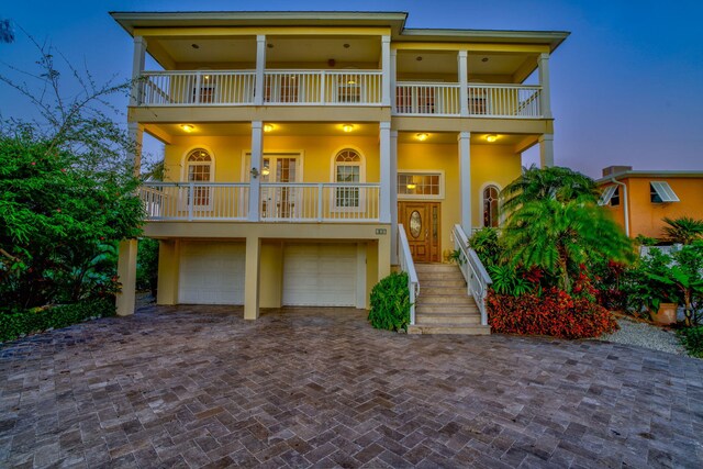 160 1st St, Key Colony, FL 33051 - view of front facade with a balcony, an attached garage, stucco siding, and decorative driveway