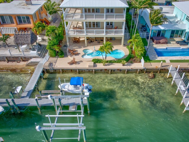 160 1st St, Key Colony, FL 33051 - dock featuring boat lift, a balcony, a patio area, an outdoor pool, and an outdoor hot tub