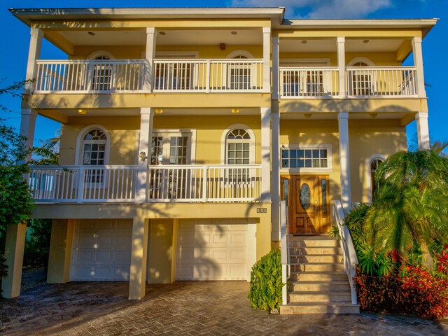 160 1st St, Key Colony, FL 33051 - view of front of home with a balcony, stucco siding, an attached garage, and decorative driveway