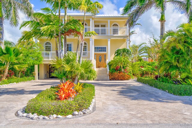 160 1st St, Key Colony, FL 33051 - view of front of home featuring decorative driveway, a balcony, stucco siding, and a carport