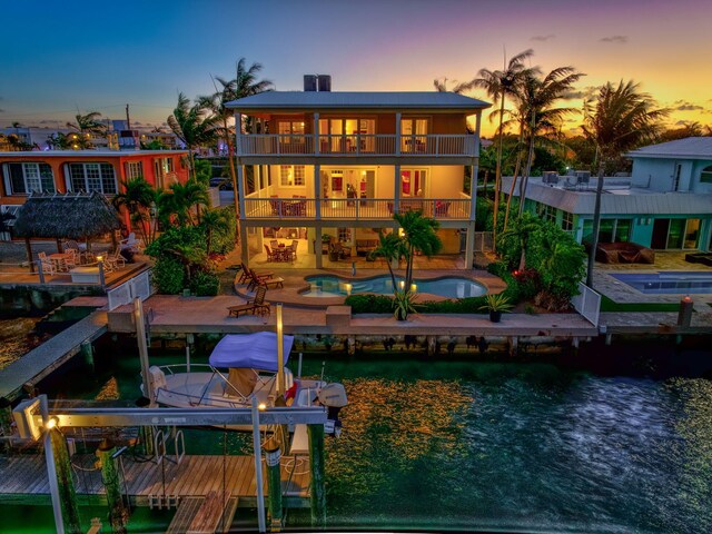 160 1st St, Key Colony, FL 33051 - back of property at dusk with a balcony, a water view, boat lift, and a patio