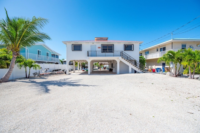 view of front of property featuring driveway, stairs, and a carport