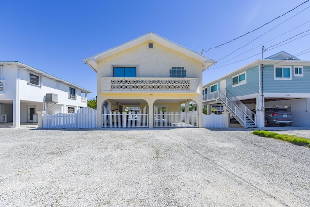 view of front facade featuring gravel driveway, fence, and stucco siding