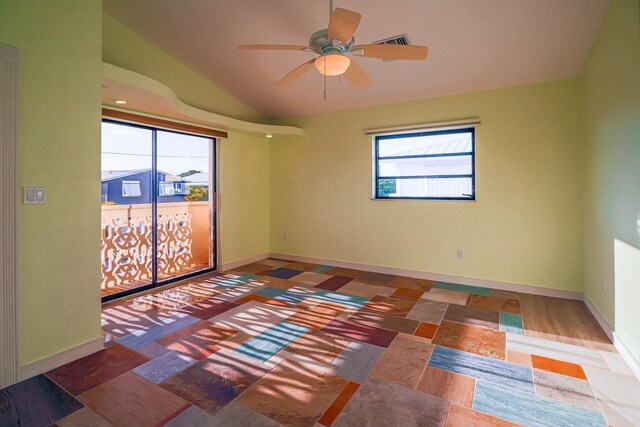 empty room featuring vaulted ceiling, ceiling fan, visible vents, and baseboards