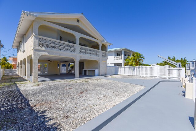 back of property featuring a carport, driveway, a patio, and fence