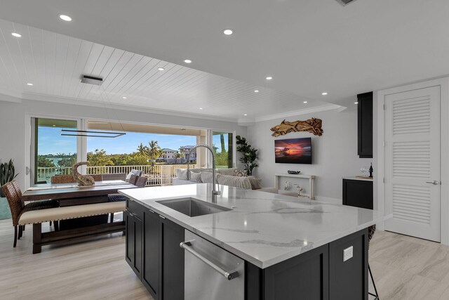 kitchen featuring stainless steel dishwasher, a sink, dark cabinetry, and crown molding