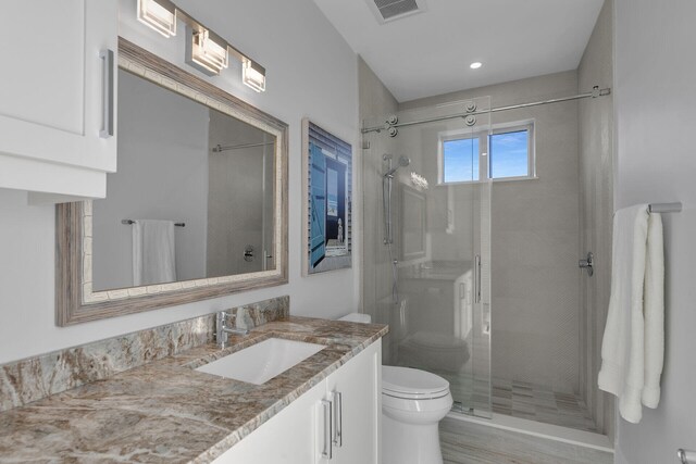 full bath featuring toilet, a stall shower, visible vents, and vanity