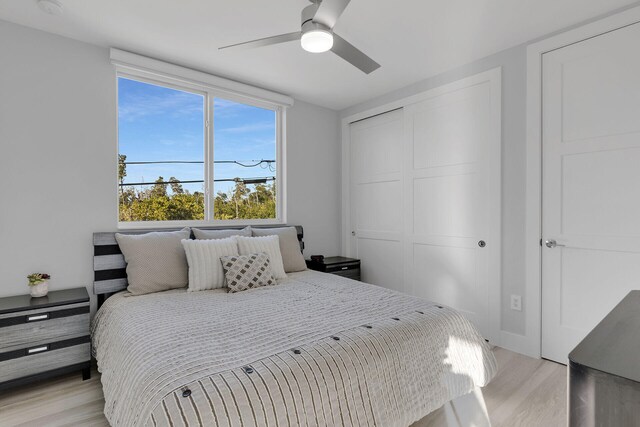 bedroom with a closet, ceiling fan, and light wood-style flooring