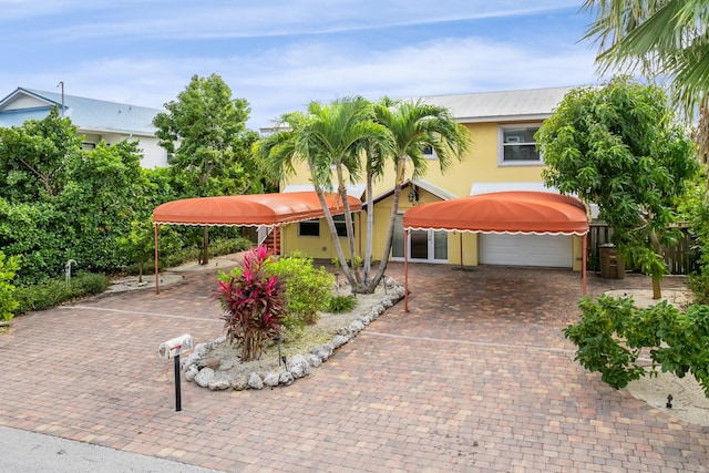 view of front of property with a garage, decorative driveway, and stucco siding