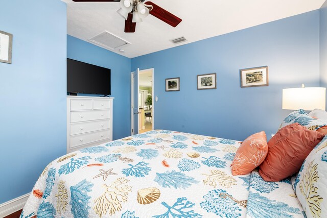 bedroom featuring attic access, visible vents, and ceiling fan