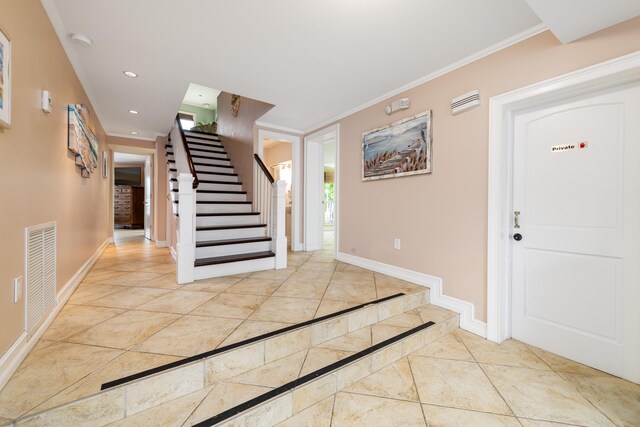 foyer with recessed lighting, visible vents, ornamental molding, baseboards, and stairs