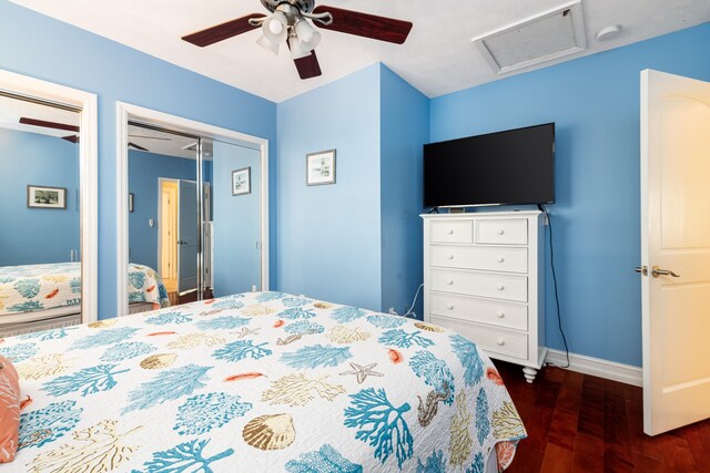 bedroom featuring attic access, baseboards, a ceiling fan, dark wood-type flooring, and multiple closets