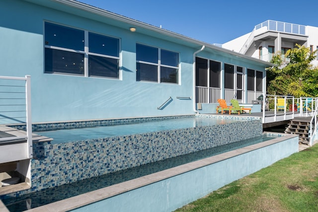 exterior space featuring a sunroom, a deck, and stucco siding