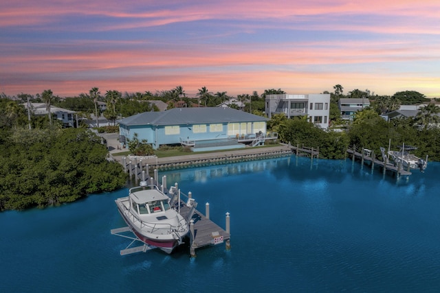 aerial view at dusk featuring a water view