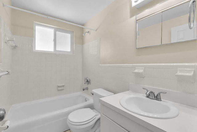 bathroom featuring vanity, wainscoting, tile walls, toilet, and shower / bathtub combination