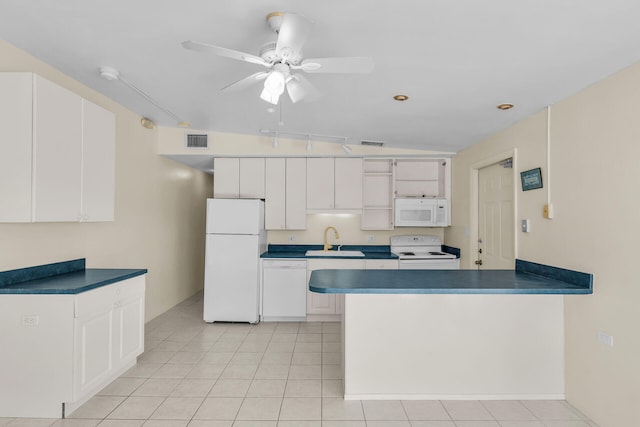 kitchen with a sink, visible vents, white appliances, and dark countertops