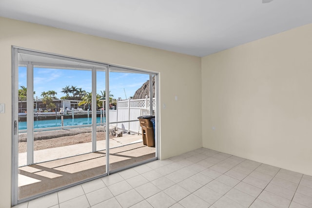 empty room featuring a water view and tile patterned flooring