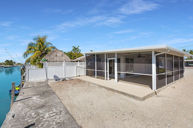 exterior space featuring fence, a water view, and a sunroom