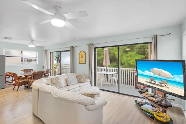 living room featuring a ceiling fan, visible vents, and light wood-style floors