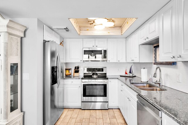 1001 Ocean Dr Unit 1-305, Key Colony, FL 33051 - kitchen with appliances with stainless steel finishes, a raised ceiling, white cabinets, and backsplash