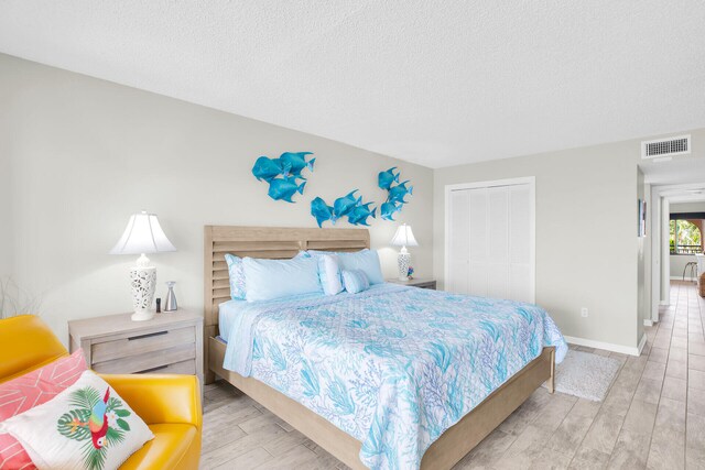 1001 Ocean Dr Unit 1-305, Key Colony, FL 33051 - bedroom featuring wood finished floors, a textured ceiling, and a closet