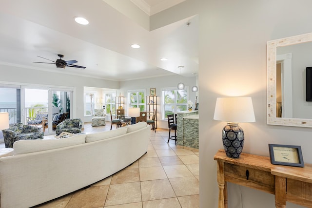 living room with crown molding, light tile patterned floors, plenty of natural light, and a ceiling fan