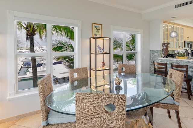 dining space featuring crown molding, tile patterned floors, visible vents, and baseboards