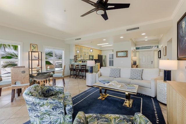 living room featuring visible vents, a ceiling fan, crown molding, and light tile patterned floors