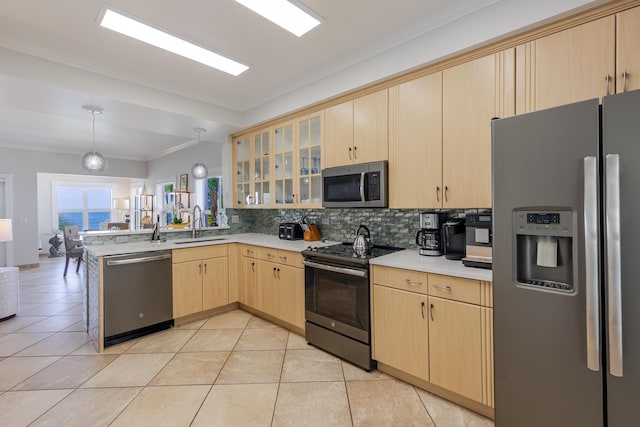 kitchen with a peninsula, light brown cabinetry, light countertops, tasteful backsplash, and appliances with stainless steel finishes
