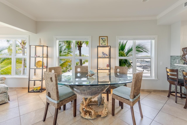 dining space with light tile patterned floors, ornamental molding, and a healthy amount of sunlight