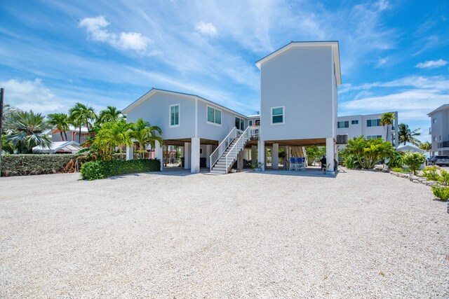 930 80th St, Marathon, FL 33050 - view of building exterior featuring a carport, stairs, and driveway