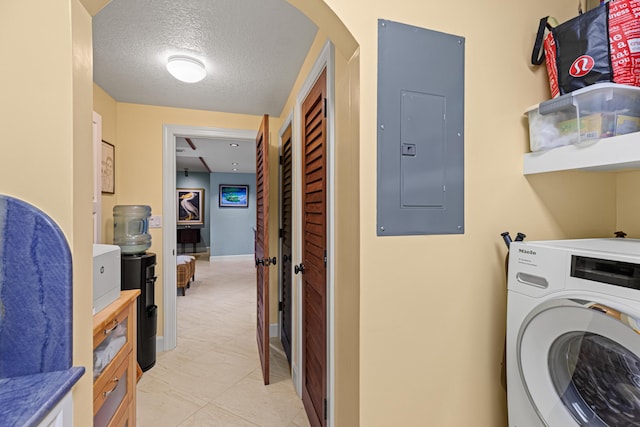 washroom with laundry area, electric panel, baseboards, washer / clothes dryer, and a textured ceiling