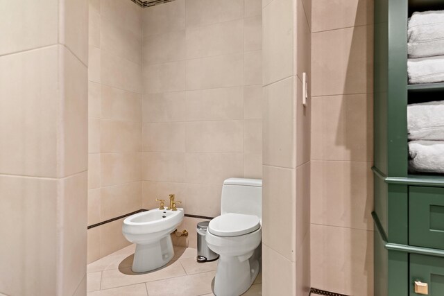 bathroom featuring tile patterned flooring, a bidet, tile walls, and toilet