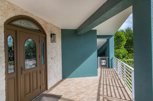 entrance to property featuring a balcony and stucco siding