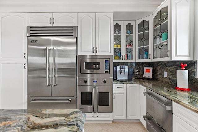 kitchen with white cabinetry, glass insert cabinets, and built in appliances