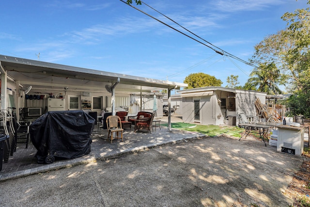 back of property with an outdoor structure and a patio