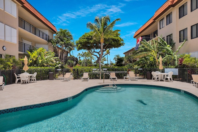 community pool featuring fence and a patio