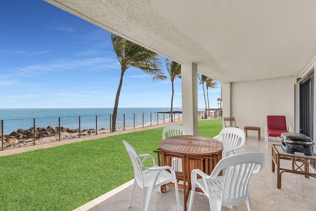view of patio / terrace with a water view and fence