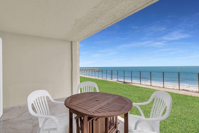 balcony featuring a water view and a beach view
