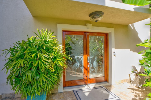 doorway to property featuring french doors and stucco siding