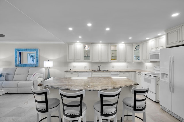 kitchen featuring white appliances, a sink, light stone counters, and decorative backsplash