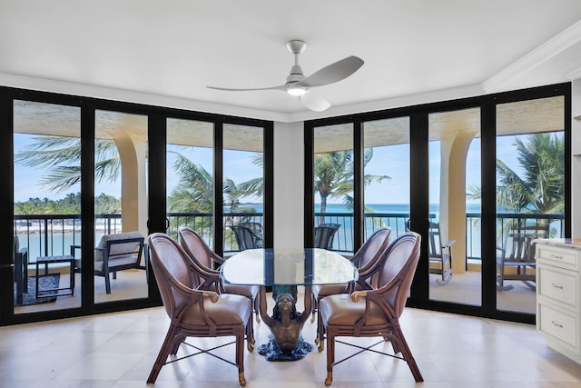 dining space featuring floor to ceiling windows, a water view, a healthy amount of sunlight, and ceiling fan