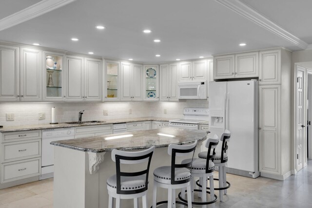 kitchen featuring a sink, white cabinetry, white appliances, and light stone countertops