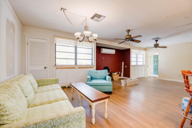 living area with a notable chandelier, visible vents, wood finished floors, and a wall mounted AC