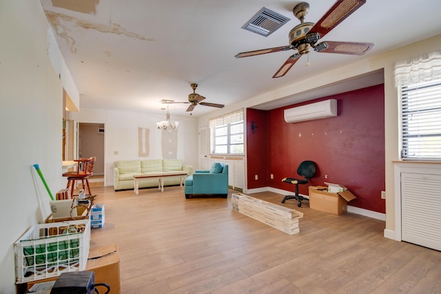 interior space featuring ceiling fan with notable chandelier, light wood-style flooring, a wall unit AC, and visible vents