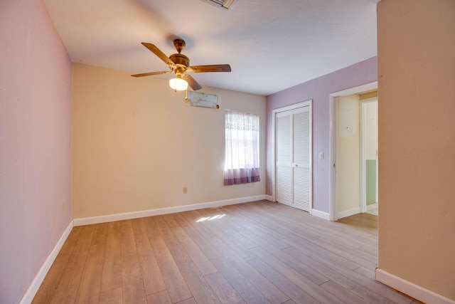 unfurnished room featuring light wood finished floors, a ceiling fan, and baseboards