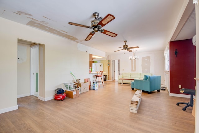 interior space with light wood-style floors, baseboards, and ceiling fan with notable chandelier