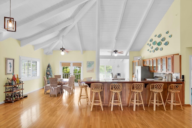 835 70th St, Gulf, Marathon, FL 33050 - kitchen with refrigerator with ice dispenser, a ceiling fan, light wood-style flooring, a breakfast bar area, and beam ceiling